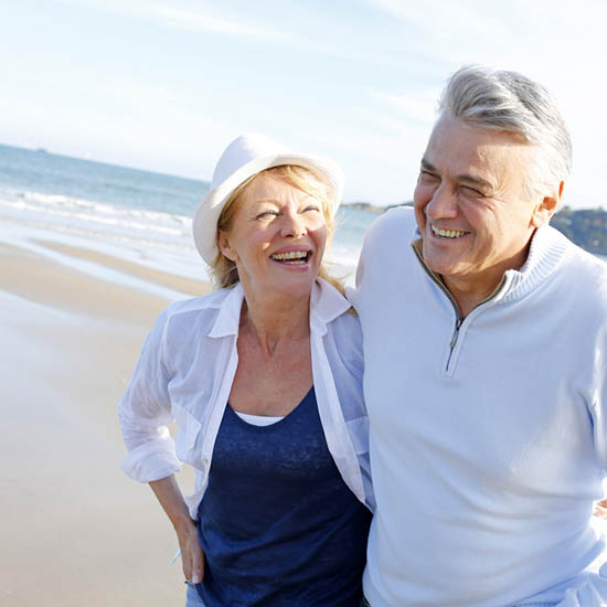 Senior couple walking on the beach in fall season